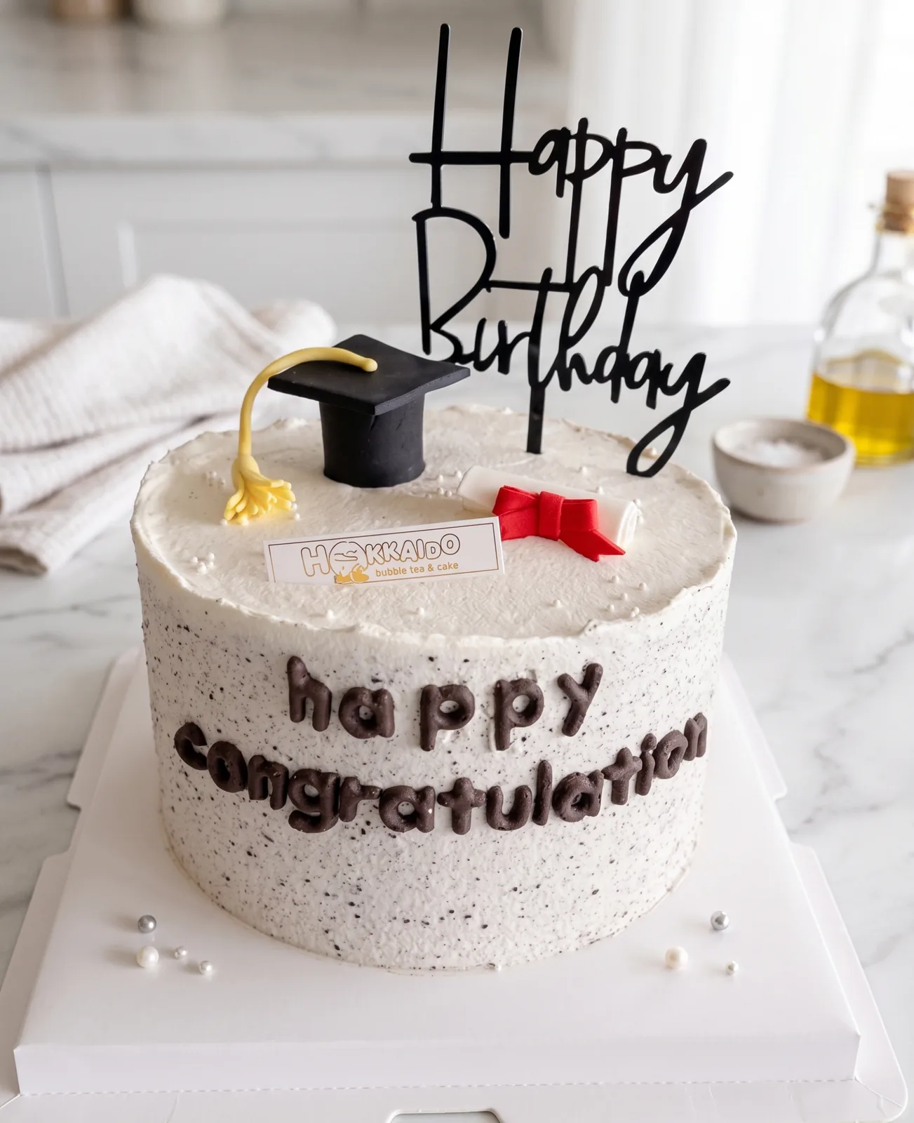 Graduation cake with black mortarboard topper and Happy Birthday sign